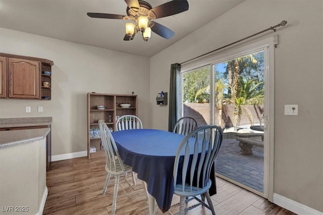 dining room with light wood-style flooring, a ceiling fan, and baseboards