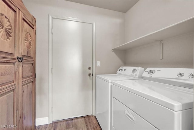 laundry area with washer and clothes dryer, laundry area, and light wood finished floors