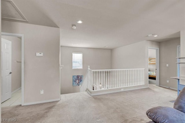 sitting room featuring carpet, an upstairs landing, and baseboards