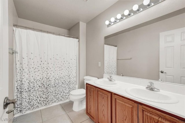 bathroom featuring tile patterned flooring, double vanity, toilet, and a sink