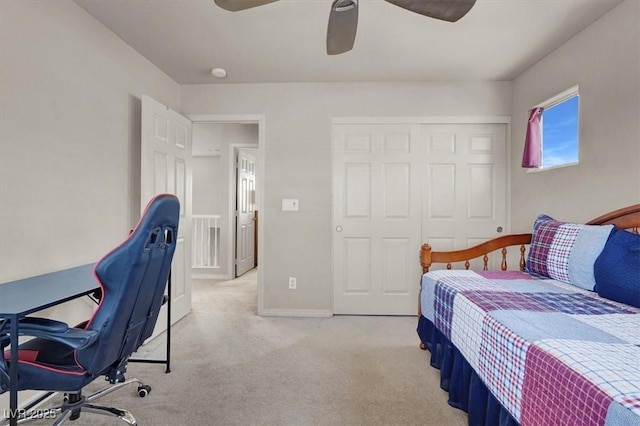 bedroom featuring a closet, light colored carpet, a ceiling fan, and baseboards