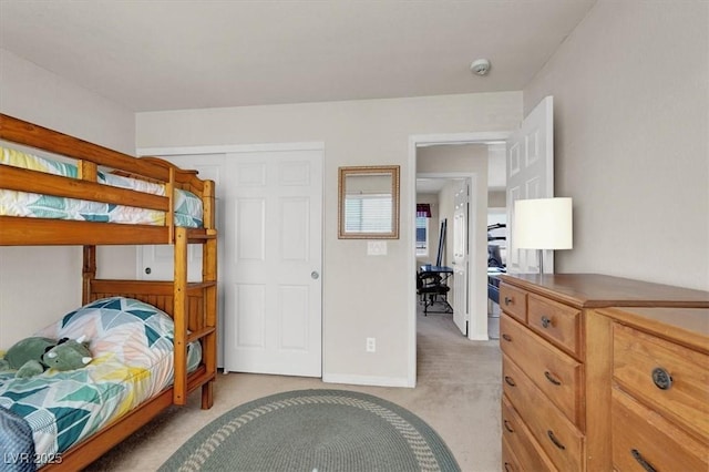 bedroom with baseboards and light colored carpet