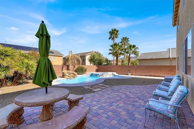 view of patio / terrace with a pool with connected hot tub and a fenced backyard