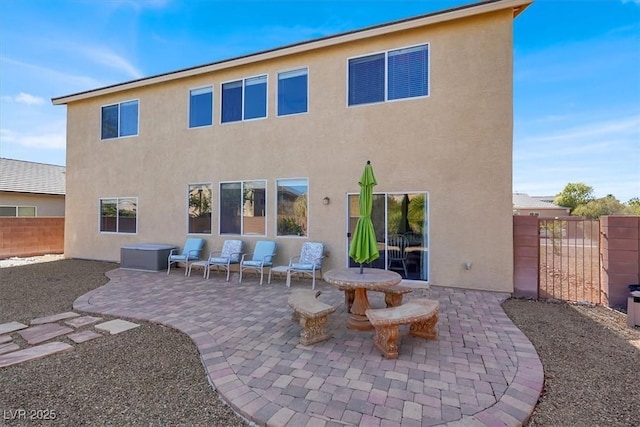 back of house featuring stucco siding, a patio, and fence