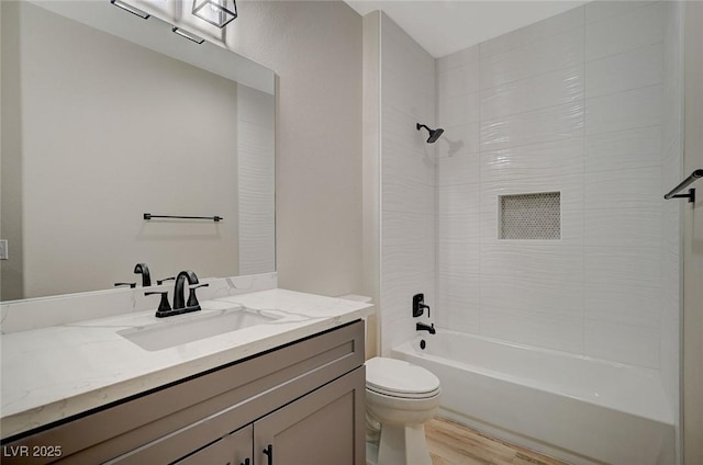 full bathroom featuring toilet,  shower combination, wood finished floors, and vanity