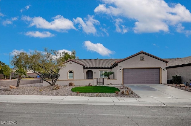 mediterranean / spanish-style house with a tiled roof, a garage, driveway, and stucco siding