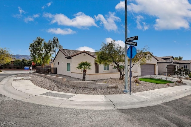 view of front of property with a tile roof, concrete driveway, a garage, and stucco siding