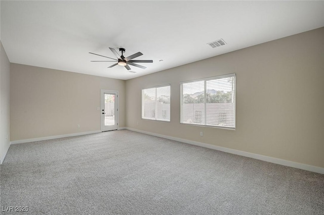 empty room featuring visible vents, baseboards, light colored carpet, and ceiling fan