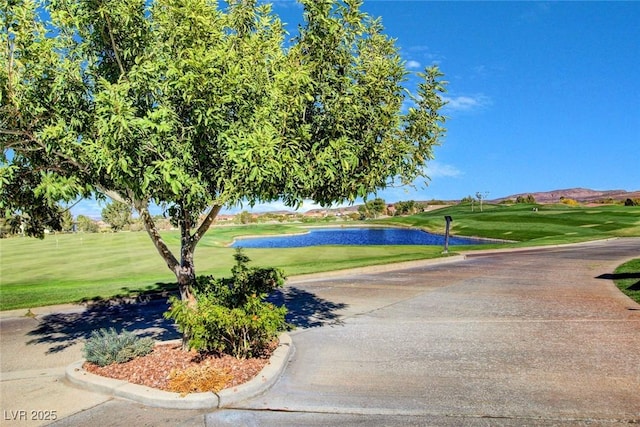 exterior space with curbs, golf course view, and a water view