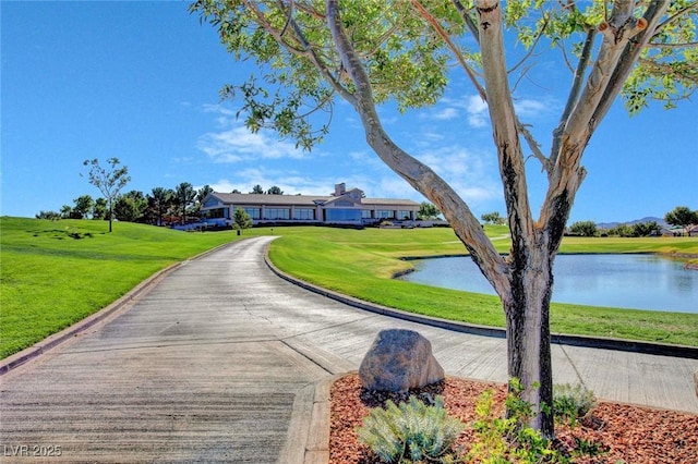 surrounding community with a water view and a lawn