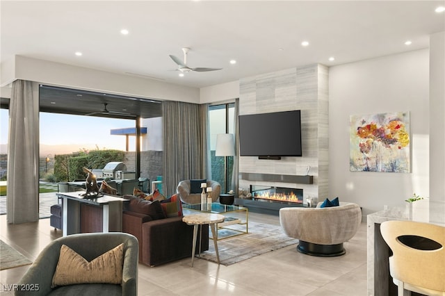 living area featuring a tiled fireplace, recessed lighting, and a ceiling fan