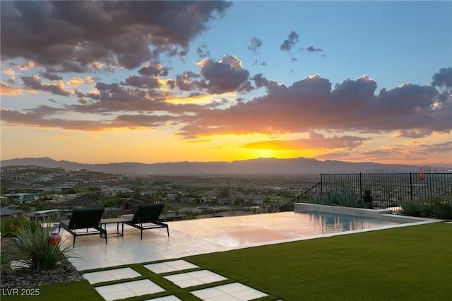 515 Serenity Point Dr, Henderson, NV 89012 - yard at dusk with a patio, a mountain view, and an infinity pool