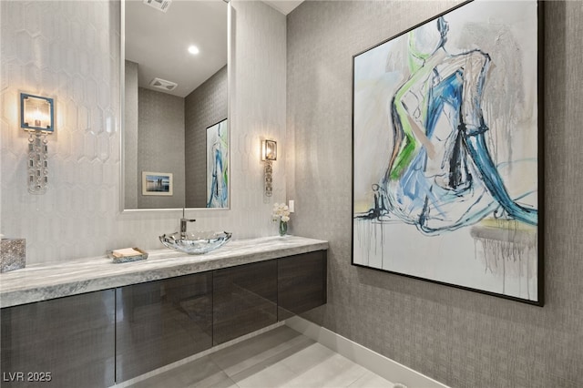 bathroom featuring visible vents, baseboards, vanity, and tile patterned flooring