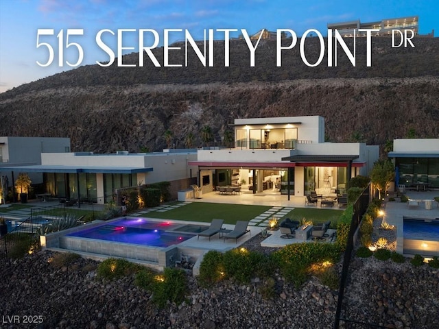 515 Serenity Point Dr, Henderson, NV 89012 - back of house featuring an in-ground hot tub, a patio, a mountain view, and stucco siding