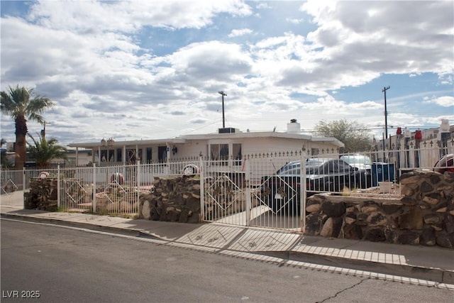 view of front of property with a fenced front yard and a gate