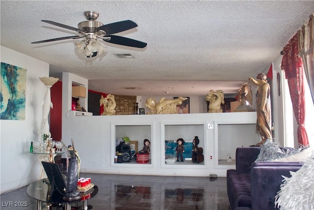 interior space featuring visible vents, built in shelves, a textured ceiling, and a ceiling fan