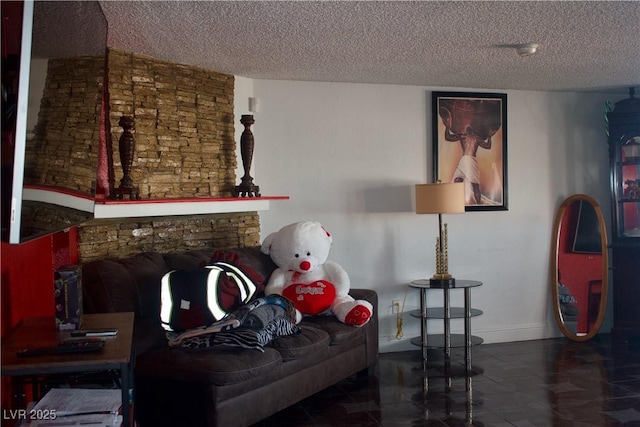 living room with a stone fireplace, a textured ceiling, and baseboards