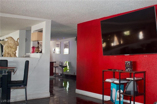 interior space featuring tile patterned floors, baseboards, and a textured ceiling