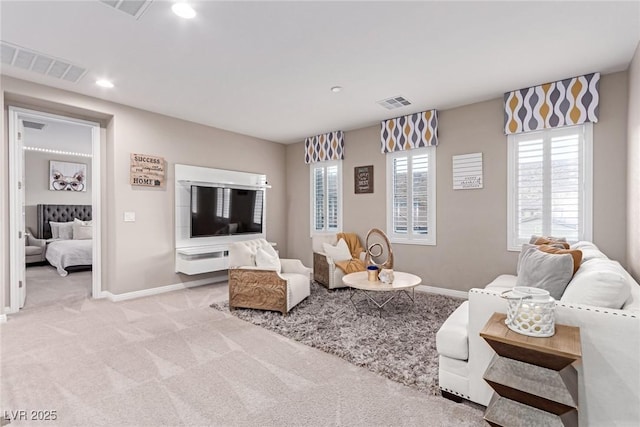 living room featuring visible vents, baseboards, and light colored carpet