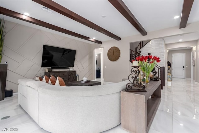 living room featuring beamed ceiling, visible vents, recessed lighting, stairway, and an accent wall