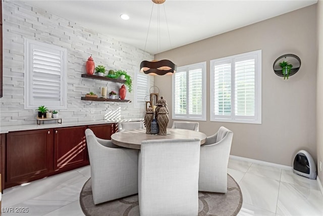 dining room featuring baseboards and light tile patterned flooring