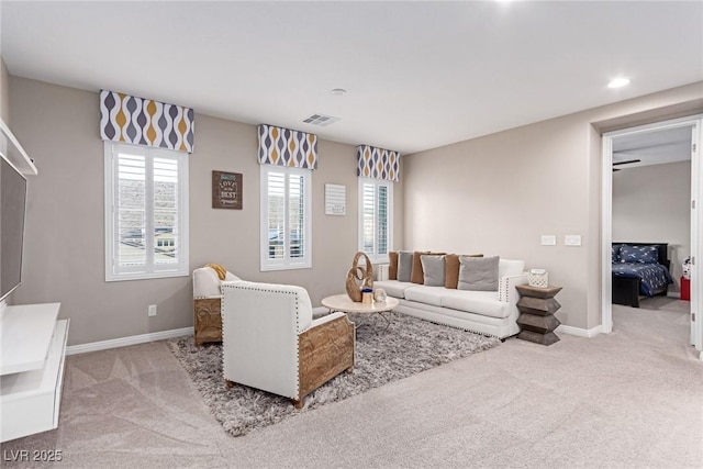 living area featuring visible vents, baseboards, and carpet flooring