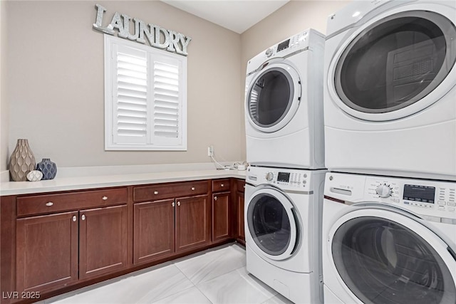 washroom with washer and dryer, stacked washer and dryer, and cabinet space