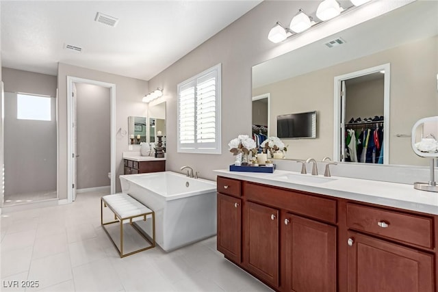 full bathroom with a soaking tub, visible vents, and a wealth of natural light