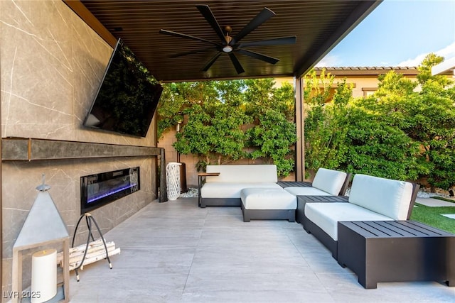 view of patio / terrace with an outdoor living space with a fireplace and ceiling fan