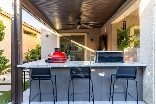 view of patio featuring exterior kitchen and a ceiling fan