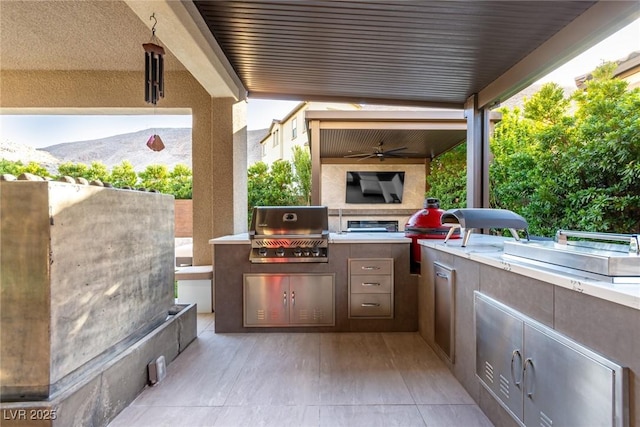 view of patio with area for grilling, a ceiling fan, and a grill