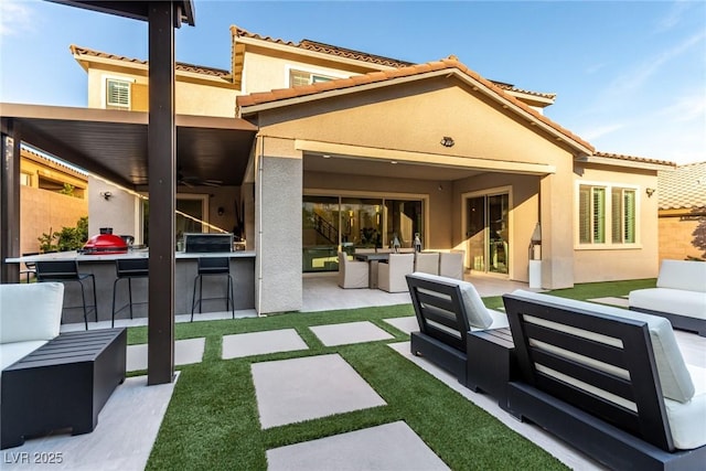 back of property featuring stucco siding, an outdoor hangout area, a patio, and fence