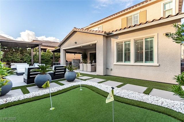 back of house featuring stucco siding, a patio, outdoor lounge area, and a tiled roof