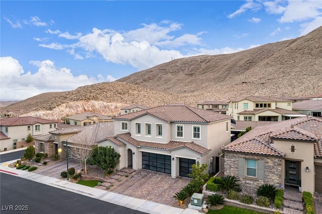 view of front of property featuring driveway, stone siding, a residential view, and stucco siding