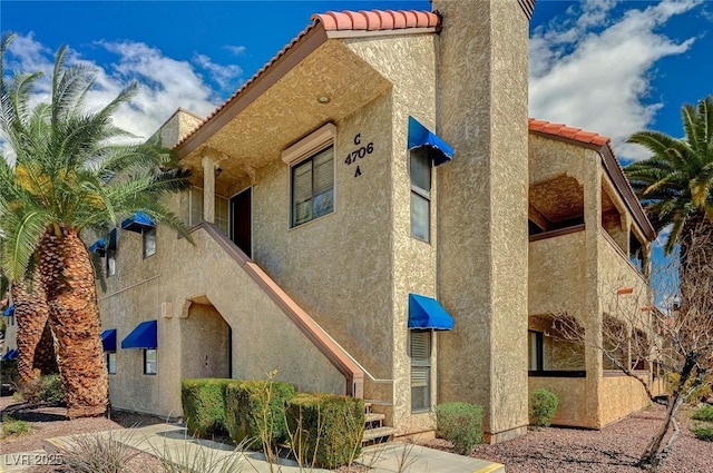 view of home's exterior with a tiled roof and stucco siding