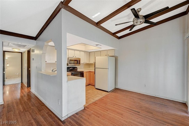 kitchen featuring visible vents, freestanding refrigerator, light countertops, black range with electric stovetop, and stainless steel microwave