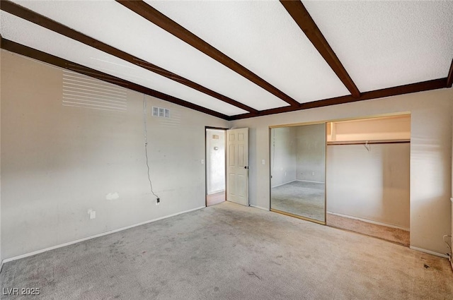 unfurnished bedroom with visible vents, light carpet, lofted ceiling with beams, a textured ceiling, and baseboards