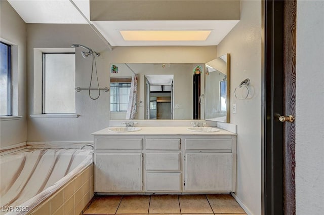 bathroom featuring double vanity, a bath, tile patterned floors, and a sink