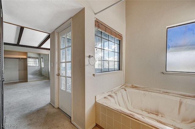 bathroom with plenty of natural light, a bath, and baseboards