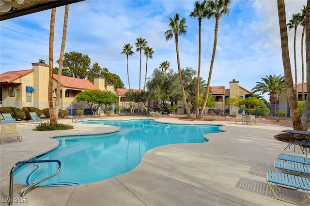 community pool featuring a patio and fence