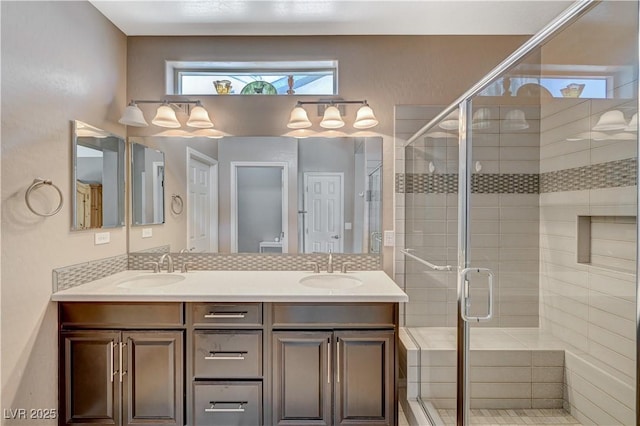 bathroom featuring a sink, double vanity, and a shower stall