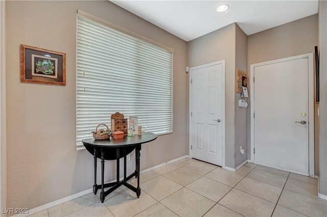 foyer featuring light tile patterned floors and baseboards