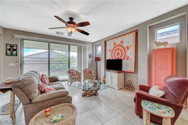 living area featuring light tile patterned floors, visible vents, and a ceiling fan