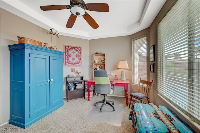 home office with baseboards, a raised ceiling, carpet floors, and ceiling fan