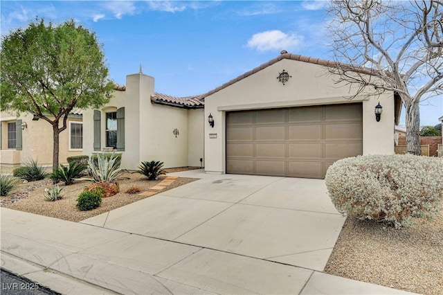 mediterranean / spanish-style home with stucco siding, a garage, driveway, and a tile roof