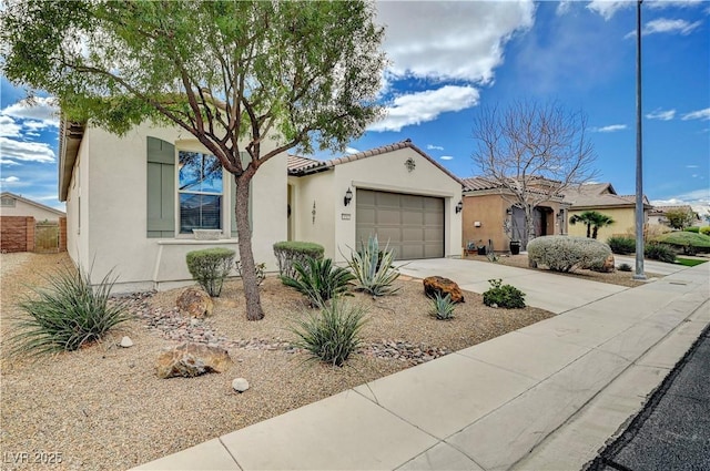 mediterranean / spanish-style home with stucco siding, a garage, driveway, and a tiled roof