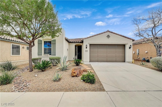 mediterranean / spanish home featuring stucco siding, concrete driveway, a tile roof, and a garage