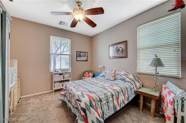 carpeted bedroom featuring visible vents, baseboards, and a ceiling fan