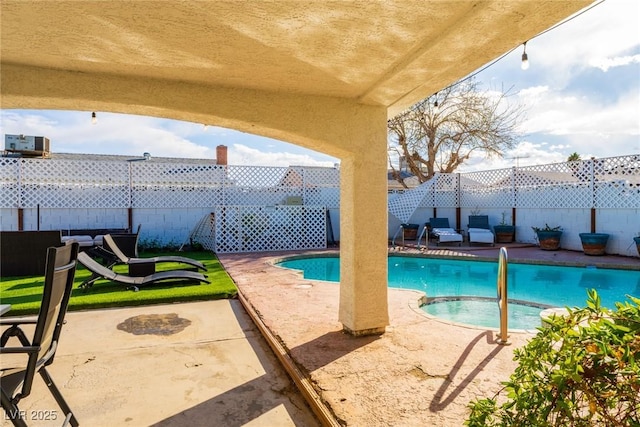 view of swimming pool featuring a patio, a fenced backyard, and a pool with connected hot tub