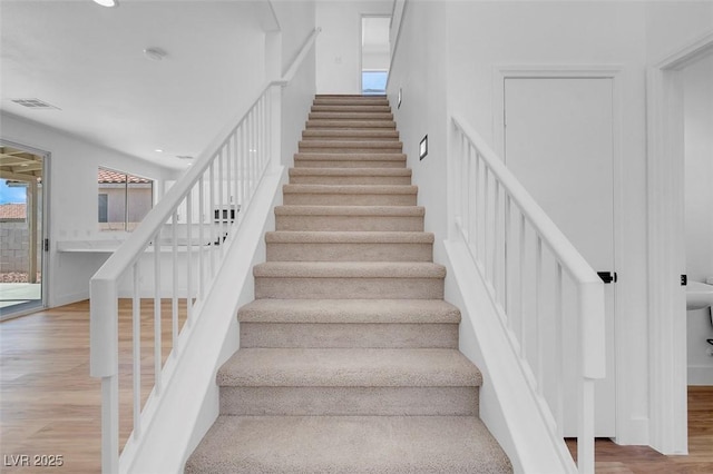 stairs featuring recessed lighting, wood finished floors, and visible vents